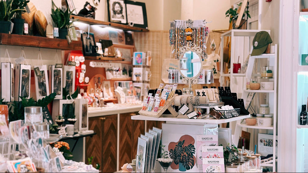 Store interior with various products on shelves and display tables.